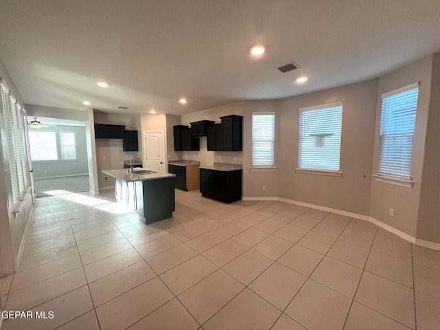 kitchen with recessed lighting, a sink, visible vents, and dark cabinets