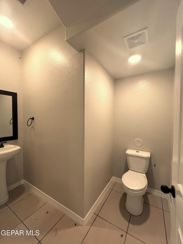 bathroom with toilet, tile patterned flooring, visible vents, and baseboards