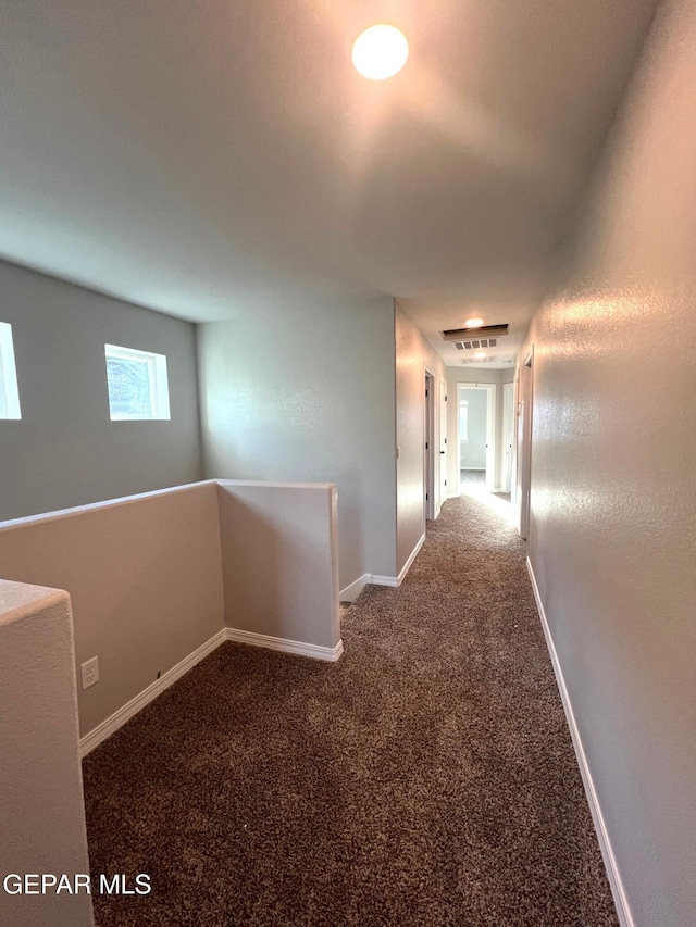 corridor featuring carpet, an upstairs landing, and baseboards