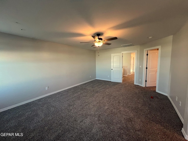 unfurnished bedroom with ceiling fan, dark carpet, visible vents, and baseboards