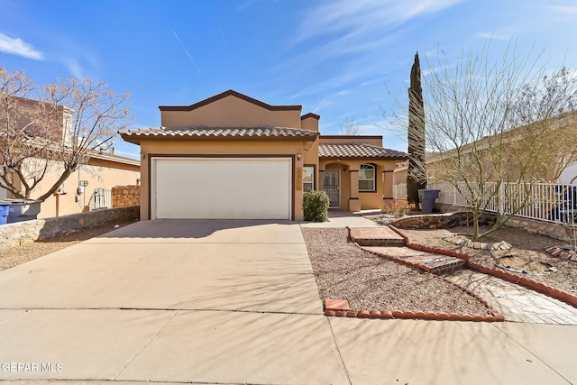 mediterranean / spanish home featuring driveway, an attached garage, fence, and stucco siding