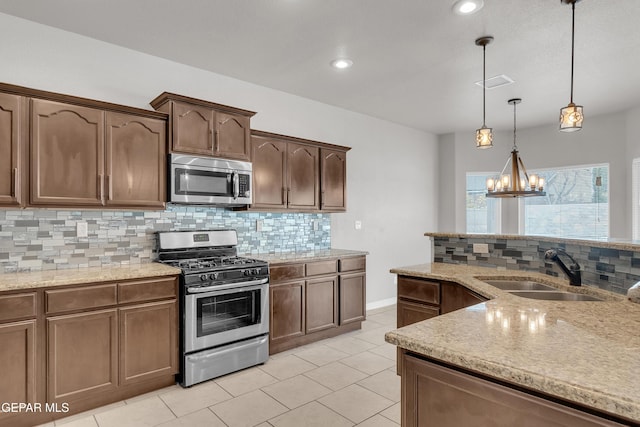 kitchen with visible vents, decorative backsplash, appliances with stainless steel finishes, pendant lighting, and a sink