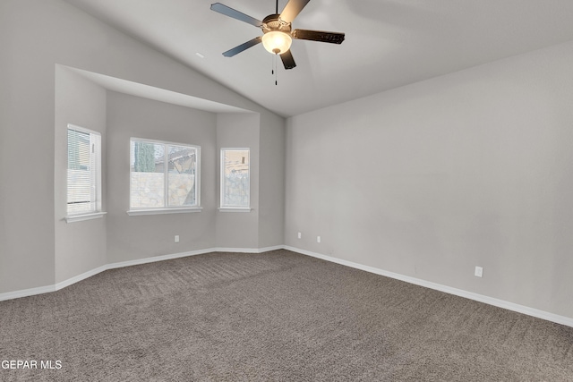 carpeted spare room featuring lofted ceiling, ceiling fan, and baseboards