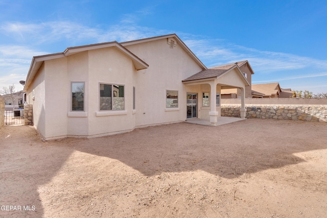 back of property featuring a patio area, fence, and stucco siding