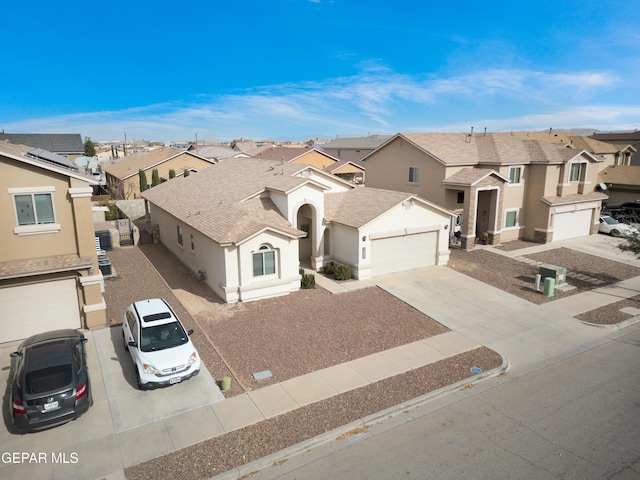 view of property featuring driveway, a residential view, and stucco siding