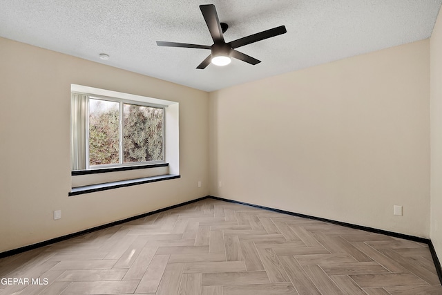 empty room featuring a ceiling fan, baseboards, and a textured ceiling