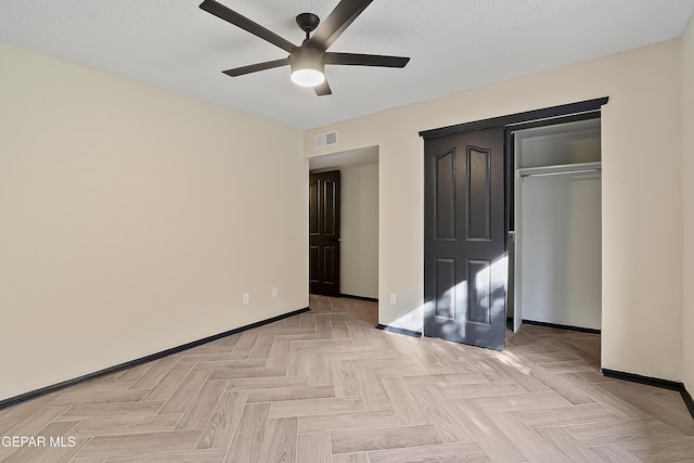 unfurnished bedroom with ceiling fan, a textured ceiling, visible vents, baseboards, and a closet