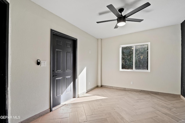 unfurnished room with baseboards and a ceiling fan