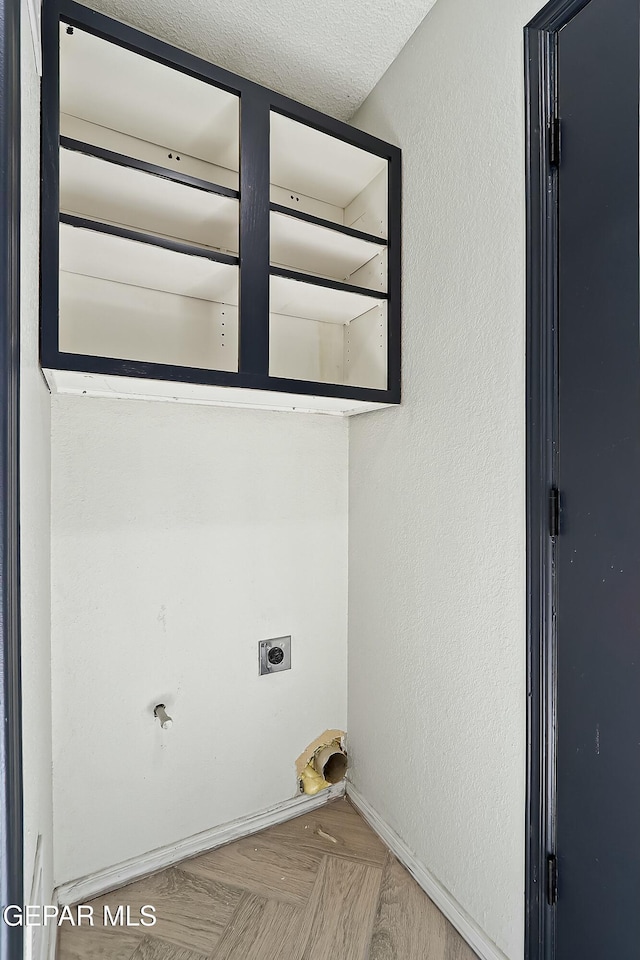 laundry room featuring laundry area, a textured ceiling, hookup for an electric dryer, and a textured wall