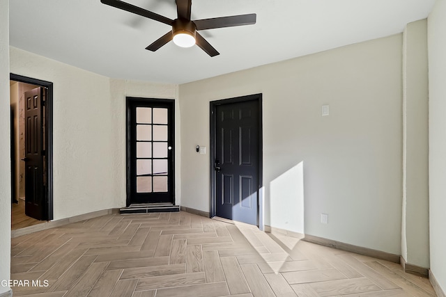 entrance foyer with ceiling fan and baseboards