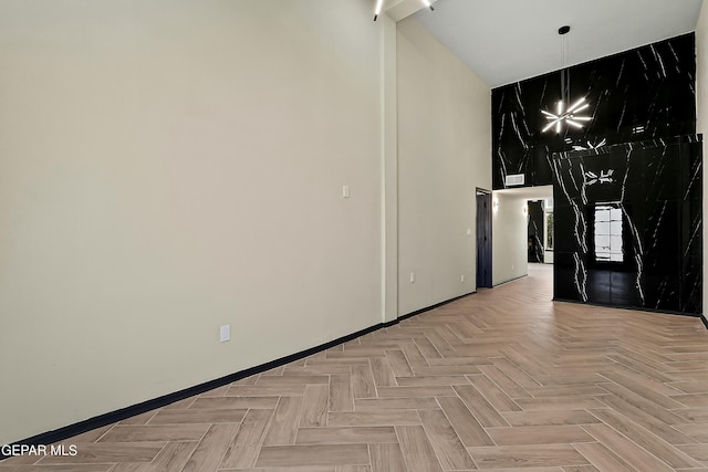 empty room featuring a towering ceiling and baseboards