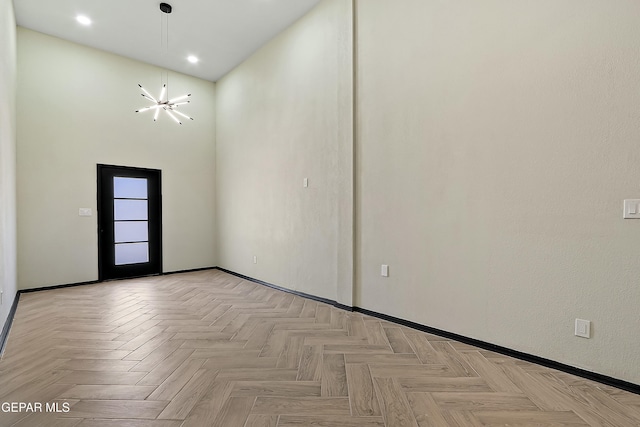 spare room with a chandelier and a towering ceiling