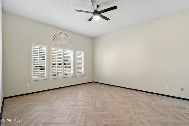 spare room featuring ceiling fan, a textured ceiling, and baseboards