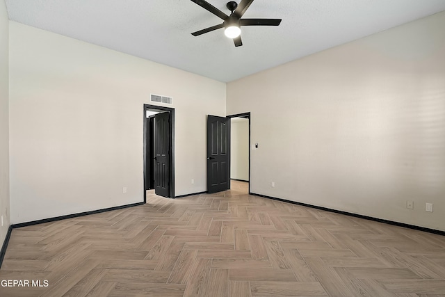 unfurnished room with ceiling fan, a textured ceiling, visible vents, and baseboards