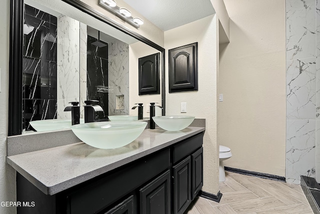 bathroom with a sink, toilet, and double vanity