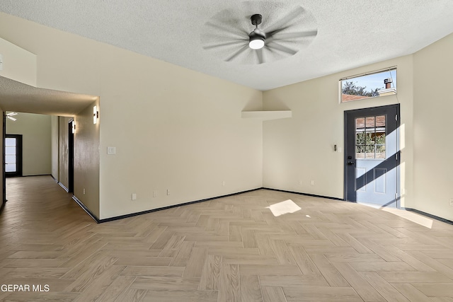 spare room with a textured ceiling and baseboards