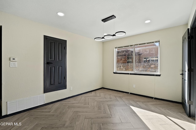 empty room featuring recessed lighting, visible vents, a notable chandelier, and baseboards