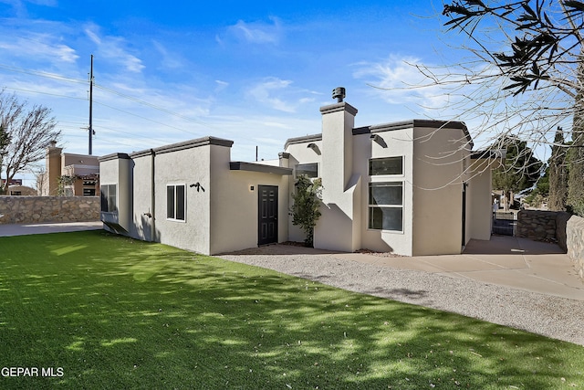 back of house featuring a yard, fence, and stucco siding