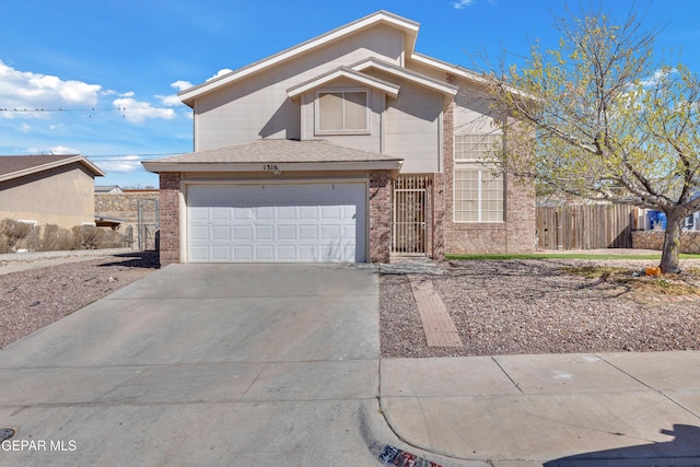 view of front of home with a garage, concrete driveway, brick siding, and fence