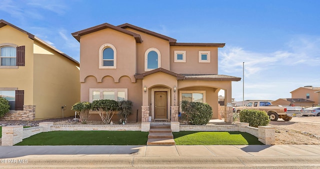 view of front of house with a front yard and stucco siding