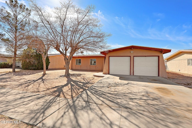 view of front of home with a garage, concrete driveway, and stucco siding