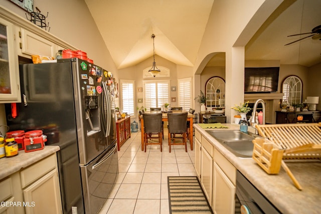 kitchen featuring vaulted ceiling, light countertops, glass insert cabinets, and decorative light fixtures