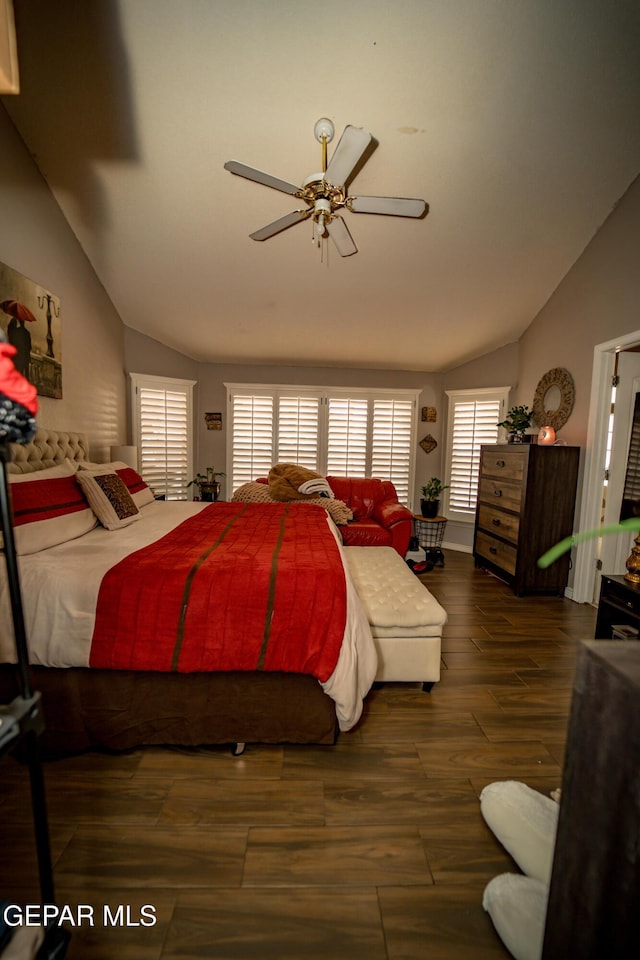 bedroom with vaulted ceiling, multiple windows, and dark wood finished floors