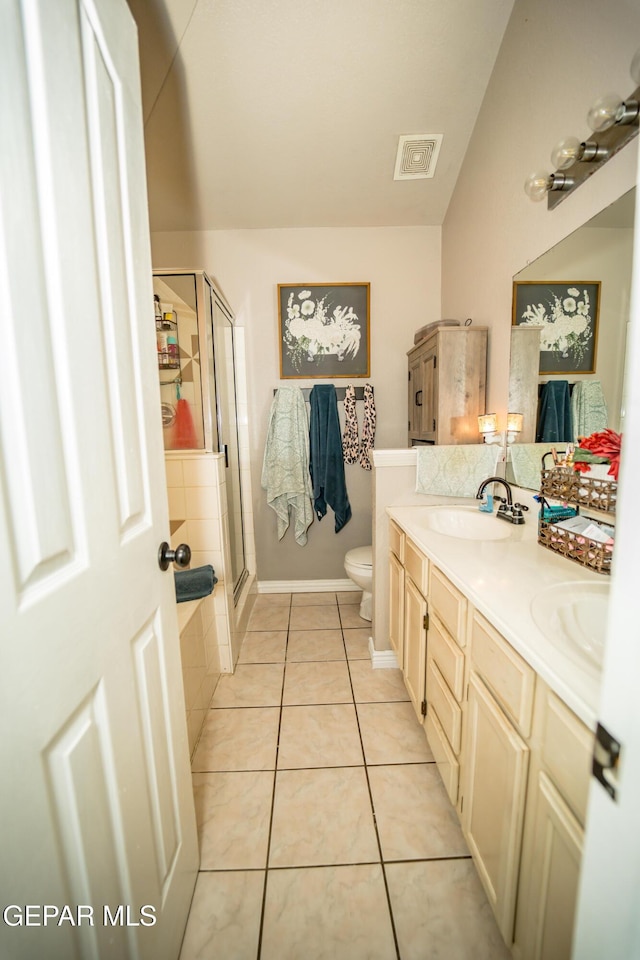 bathroom featuring a sink, visible vents, a shower stall, tile patterned floors, and double vanity