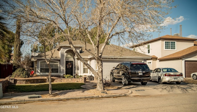 view of front of house featuring driveway, a garage, and stucco siding