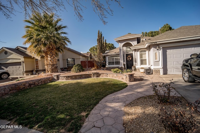 mediterranean / spanish-style house with a garage, a front yard, and stucco siding