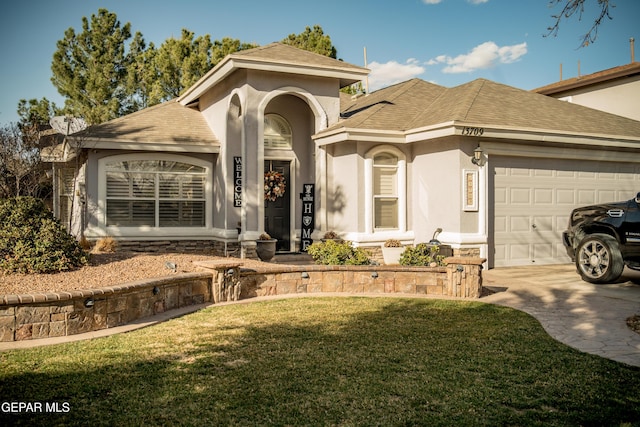 mediterranean / spanish home featuring stucco siding, a shingled roof, a front yard, a garage, and driveway