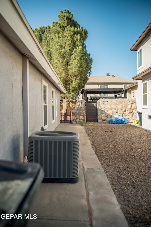 view of patio with central AC, fence, and a gate