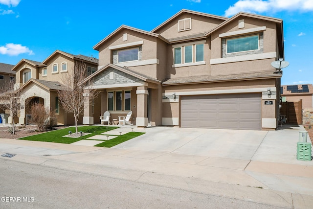 view of front of home featuring driveway, an attached garage, and stucco siding