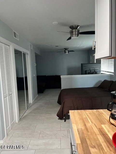 bedroom featuring ceiling fan, visible vents, and two closets