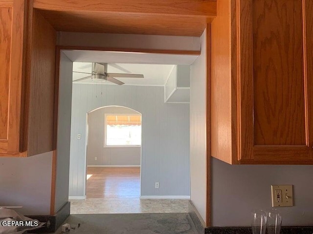 interior space with arched walkways, baseboards, and wooden walls