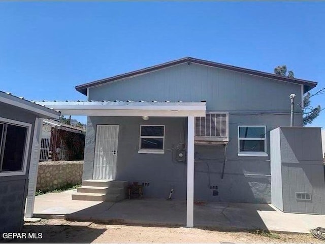 back of property with entry steps, a patio, and central AC