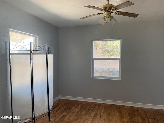 spare room with a ceiling fan, baseboards, and wood finished floors