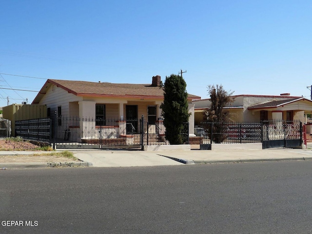 single story home with a fenced front yard and a gate