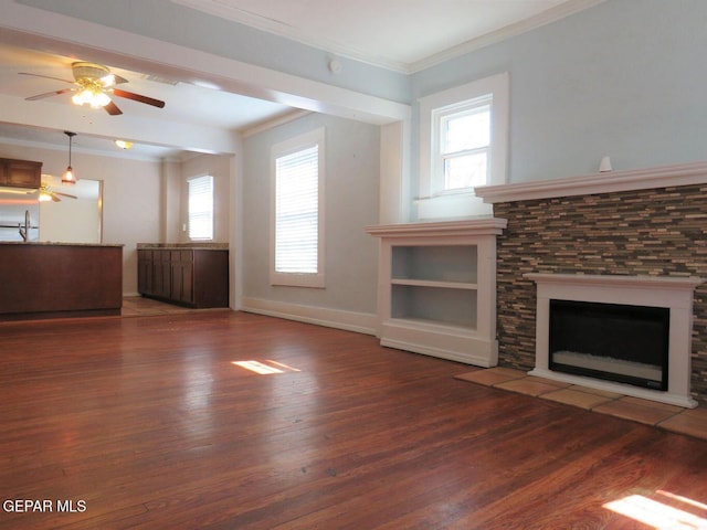 unfurnished living room featuring ornamental molding, dark wood-type flooring, a fireplace, and baseboards