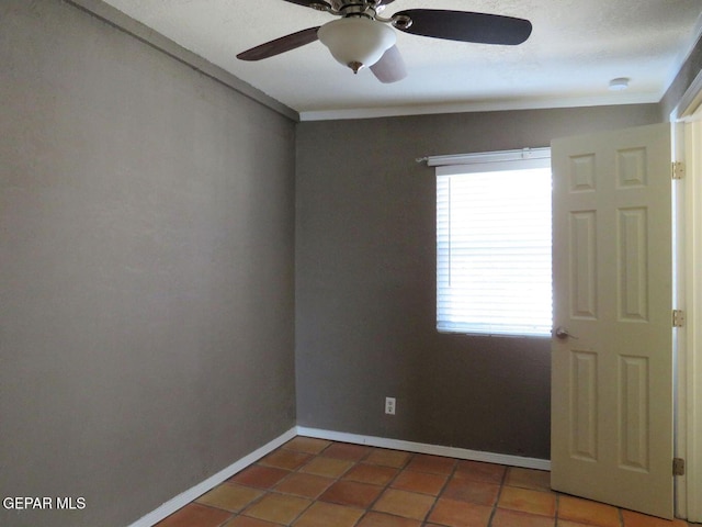 tiled empty room featuring baseboards