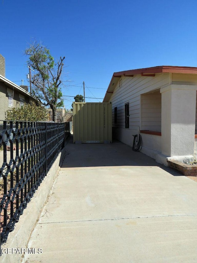 view of property exterior featuring fence and a patio