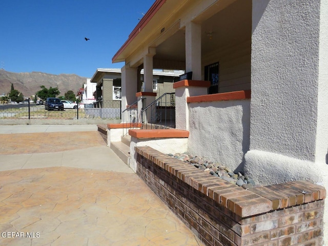 view of patio with fence and a mountain view