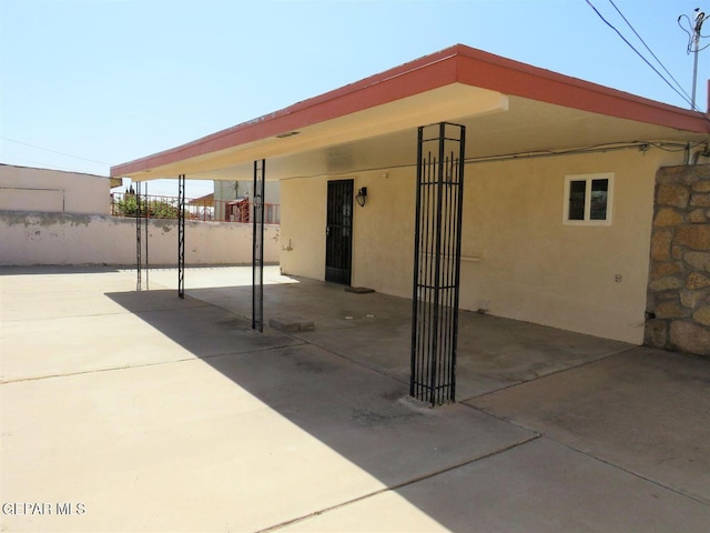 view of patio with a carport and fence