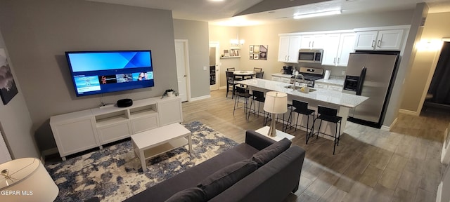 living area featuring light wood-type flooring and baseboards