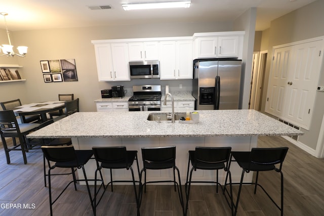 kitchen with a center island with sink, white cabinetry, and stainless steel appliances