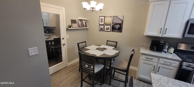 dining space with light wood-style floors, baseboards, and an inviting chandelier