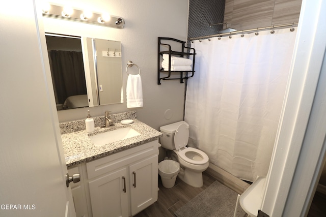 full bath featuring toilet, a shower with shower curtain, wood finished floors, and vanity