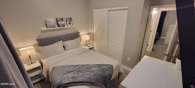 bedroom featuring a closet, wood finished floors, and baseboards