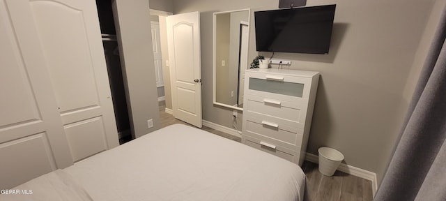 bedroom with baseboards and wood finished floors