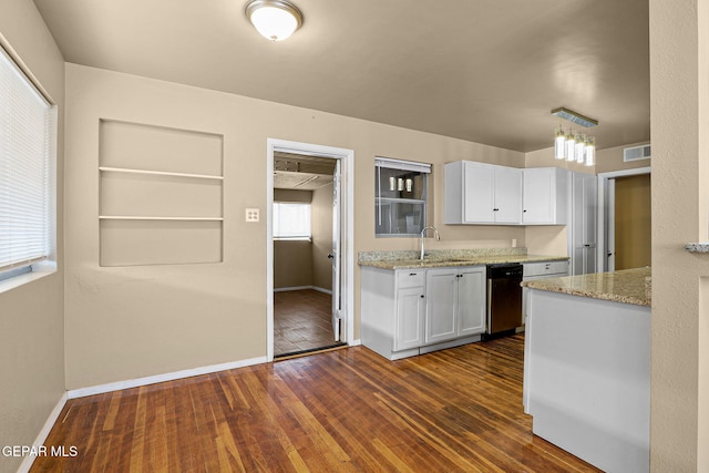 kitchen with light stone counters, dark wood-style flooring, white cabinetry, a sink, and dishwasher